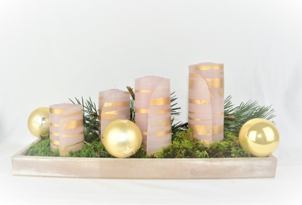 goldene Weihnachtskerzen auf Gesteck mit goldenen Kugeln